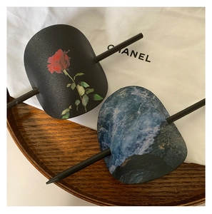 Détail de l'ensemble pince à cheveux en cuir avec épingle en bois et motif rose