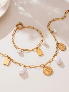 Detailed view of 18k gold plated chain jewelry with baroque pearls and coin charms