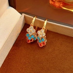Detail of three-tier gold-plated flower earrings with colorful zircon stones in a box