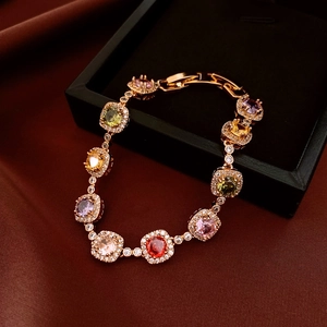 Detail of 18k gold plated bracelet with multi-color gemstones on a black velvet box