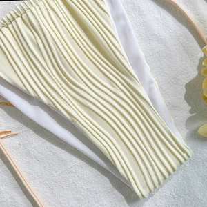 Macro shot of off-white plisse bikini fabric featuring detailed layered texture and lining