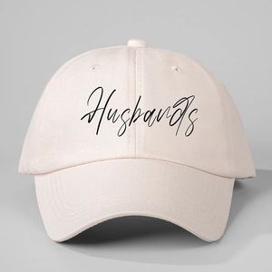 Detail view of the Husbands handwritten script print on a light pink cotton baseball cap
