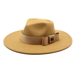 Detail of camel wool felt fedora with elegant satin band and metallic M letter accent
