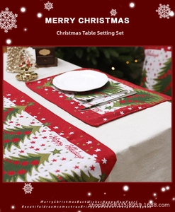 Detail of Christmas table runner and placemats with festive prints and Merry Christmas text