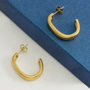 Minimalist 18k gold-plated C-shaped earrings with striped texture on a blue gift box