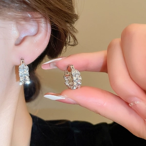 Close-up of crystal leaf-shaped ear cuffs with sparkling stones on model