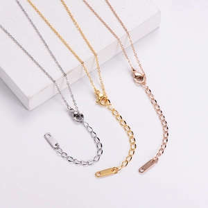 Detail of three-color titanium steel necklaces showing lobster clasps and extension chains