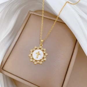 Luxurious star cross necklace with zircon crystals and shell inlay on beige jewelry box