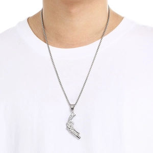 Detail of a retro silver punk revolver pistol pendant on a stainless steel chain