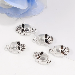 Five pieces of silver alloy skull pendants for DIY jewelry making on white background