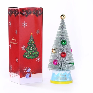 Mini lighted Christmas cedar tree with colorful ornaments and a red festive gift box