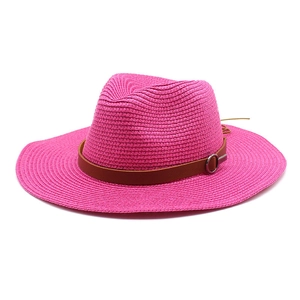 Detailed close-up of rose red woven straw panama hat with brown leather belt and metal buckle