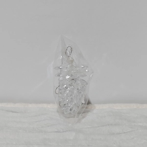 Macro detail of clear acrylic pinecone ornaments with faceted beads in packaging