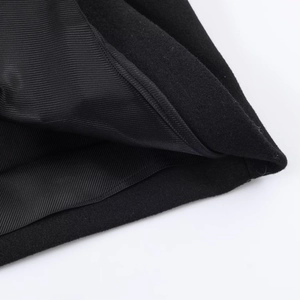 Gros plan sur le tissu en laine noir avec doublure en satin lisse d'un manteau chic