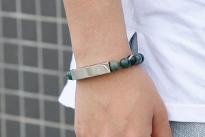Detailed side view of a turquoise marble bead bracelet with a silver brushed metal tube