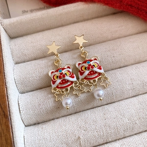 Close-up of Lion Dance earrings with gold plating, red enamel, and white pearls
