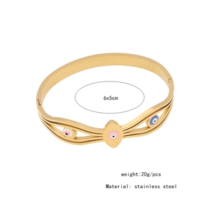 Macro detail of a gold stainless steel evil eye bangle with 6x5cm size specifications