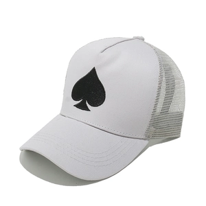 Detail of white trucker hat showing spade embroidery and breathable mesh panels