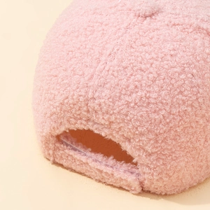 Close-up of soft pink lamb wool baseball cap texture with detailed fuzzy grain surface