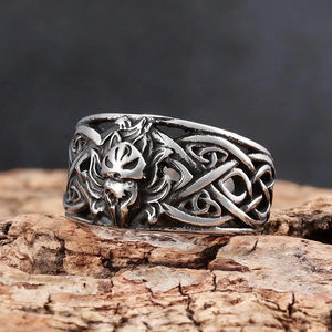 Close-up of vintage viking wolf ring with celtic knots on a rustic wooden base