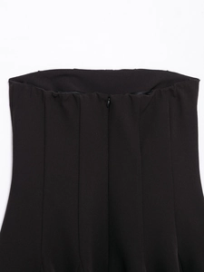 Detail of off-shoulder black dress back with hidden zipper and vertical pleated fabric