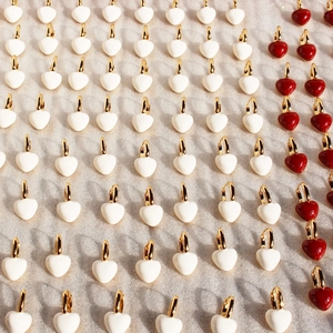 Minimalist red and white enamel heart hoop earrings displayed in a neat grid pattern