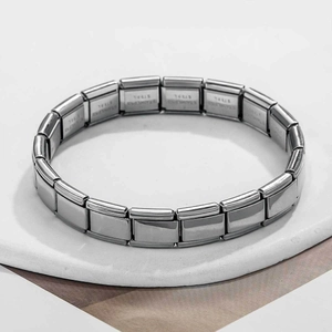 Gros plan des maillons du bracelet modulaire en acier inoxydable argenté gravé