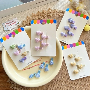 Cute heart-shaped candy colored plaid hair clips for kids on a minimalist display