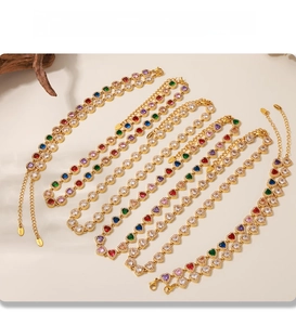 Detail of PVD gold plated bracelets featuring colorful heart-shaped zircons and gems