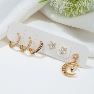 Golden 6-piece earring set featuring star studs and blue zircon hoops on display