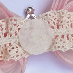 Close-up of pink tulle bow hairband featuring lace ribbon and white felt padding detail