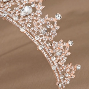 Close-up of rose gold tiara detailing intricate crystal patterns and droplet-shaped rhinestones