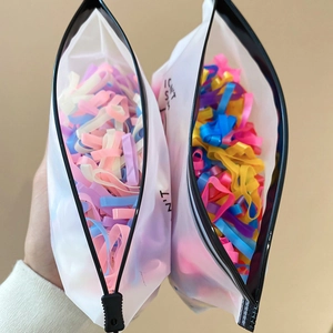 Close-up of colorful elastic hair ties in matte translucent frosted zipper bags