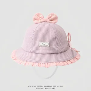 Detaillierte Textur von Baby-Cordhut mit gepunkteter Schleife und rosa Rüschenrand