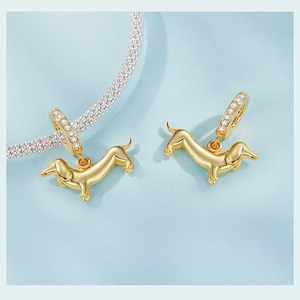 Macro shot of gold dachshund charm with white zircon accents on silver mesh bracelet