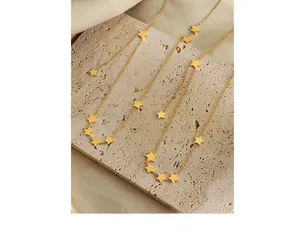 Detailed shot of star charms on gold-plated titanium steel necklace over stone base