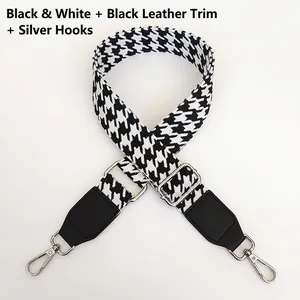 Detail of houndstooth strap with black leather connectors and silver metal swivel hooks