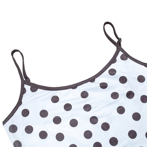 Detail of polka dot crop top with contrast trim and adjustable thin straps on white fabric
