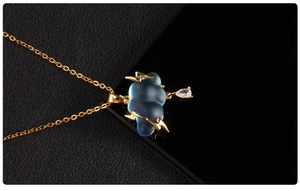 Detail of blue cloud pendant with golden lightning and crystal teardrop on gold chain