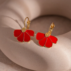 Macro shot of red enamel flower earrings with golden edges and textured petals