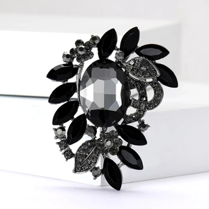 Macro shot of luxury gunmetal floral brooch with black faceted gems and grey rhinestones