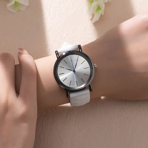 Detail of quartz watch featuring white silicone strap and silver sunray dial on wrist