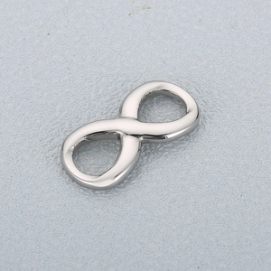Detailed view of a polished silver stainless steel infinity symbol pendant charm