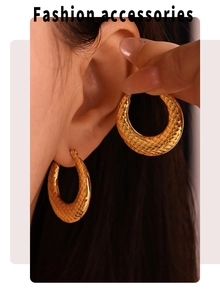 Detail view of large 18k gold plated U-shaped earrings with checkered texture on model