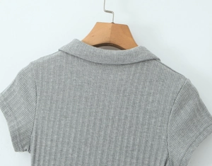 Détail de la texture en maille côtelée gris clair et du col polo de la robe courte