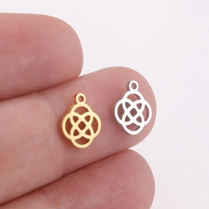 Detail of gold and silver Celtic knot evil eye pendants held between fingers