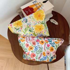 Floral print cotton makeup bag set with zipper and simple wish label on wooden table
