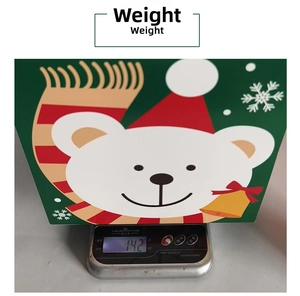 Detailed view of a green Christmas bear gift box weighing 142g on a scale