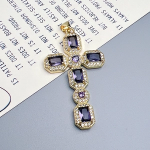 Golden cross pendant with purple zircon stones on a decorative scripture background