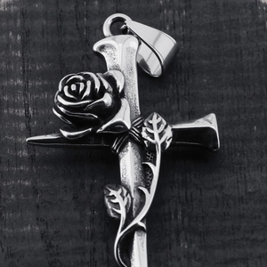 Vintage stainless steel cross pendant featuring a 3D rose and vine on a dark wood background